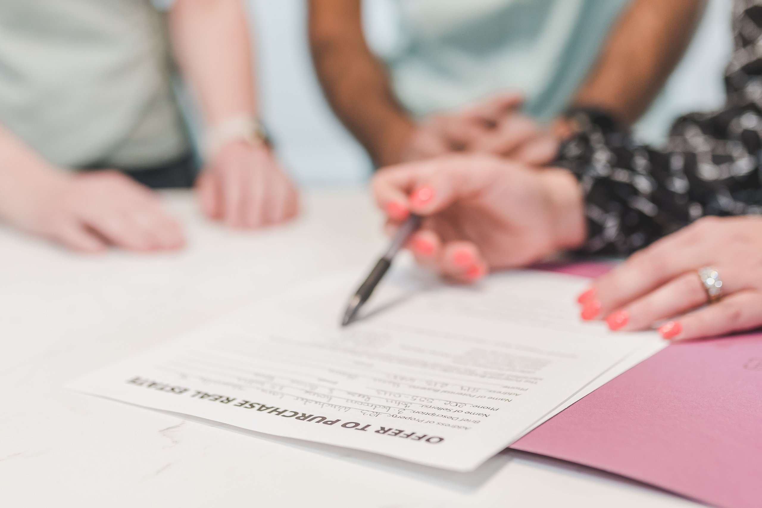 Buyers reviewing and signing an offer to purchase real estate